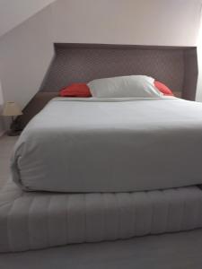 een slaapkamer met een wit bed en een hoofdeinde bij Appart cosy Disney paris in Chalifert
