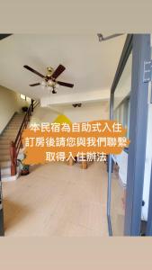 un ventilador de techo en una habitación con escritura en la pared en 念念Nian Nian Taomi Inn, en Puli