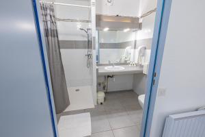 a bathroom with a shower and a sink and a toilet at Le Clos Grand in Pradines