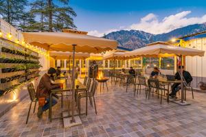 un grupo de personas sentadas en mesas en un restaurante en The Hosteller Mcleodganj, Mall Road en McLeod Ganj