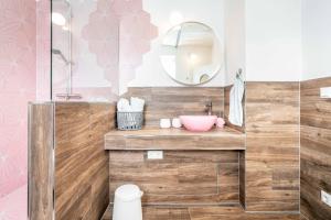 ein Badezimmer mit einem rosa Waschbecken und einem Spiegel in der Unterkunft Gustava 28 in Graal-Müritz