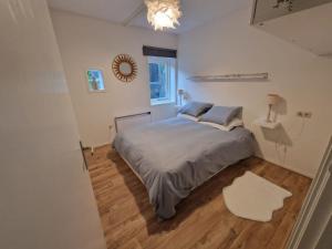 een slaapkamer met een bed, een tafel en een spiegel bij Huisje in Pieterburen in Pieterburen