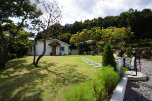 una pequeña casa blanca en medio de un patio en Praise Suite en Gapyeong