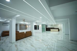 a lobby with white walls and marble floors at Hotel Mangalore Stay INN in Mangalore