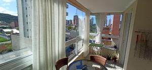 a balcony with a table and a view of a city at Apto temporada Itapema sc in Itapema