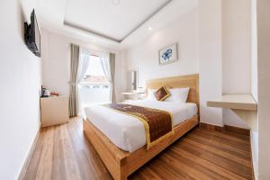 - une chambre avec un grand lit et une fenêtre dans l'établissement Golden Bee Hotel, à Đà Lạt