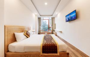 - une chambre avec un grand lit et une fenêtre dans l'établissement Golden Bee Hotel, à Đà Lạt