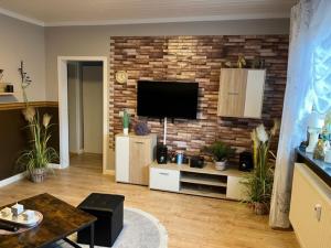 a living room with a television on a brick wall at Ferienwohnung im Harz Wohlfühltempel in Winzenburg