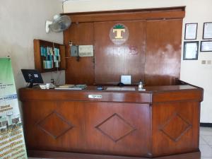 a wooden reception desk in a room at Collection O 92242 Hotel Tanjung Emas in Purwokerto