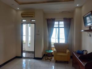 a living room with a chair and a window at Collection O 92242 Hotel Tanjung Emas in Purwokerto