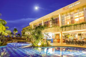 ein Hotel mit einem Pool vor einem Gebäude in der Unterkunft FUGO Banjarmasin in Banjarmasin
