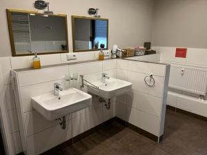 ein Badezimmer mit 2 Waschbecken und einem Spiegel in der Unterkunft Ferienwohnung im Harz Wohlfühltempel in Winzenburg