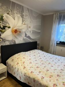 ein Schlafzimmer mit einem Bett mit Blumen an der Wand in der Unterkunft Ferienwohnung im Harz Wohlfühltempel in Winzenburg