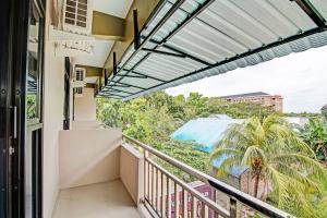 uma varanda com vista para uma palmeira em OYO 92247 Penginapan Thoybah Syariah 