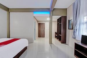 a bedroom with a bed and a television in it at OYO 92247 Penginapan Thoybah Syariah 