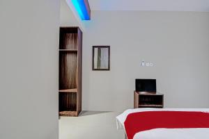 a white room with a bed and a tv at OYO 92247 Penginapan Thoybah Syariah 
