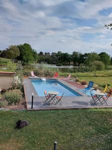 a swimming pool with chairs and a table in a yard at Au coeur de la nature in Saint-Vincent-Jalmoutiers