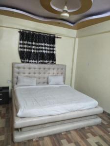 Schlafzimmer mit einem weißen Bett und einem Fenster in der Unterkunft Hotel Shiv Mahima Inn By WB Inn in Allahabad