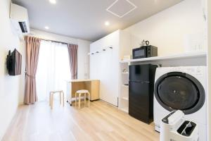 una lavanderia con lavatrice e asciugatrice di JP INN Kyoto Ekimae Izutsucho a Kyoto