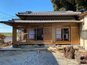 ein kleines Haus mit Glastüren an der Seite in der Unterkunft 田舎庵 in Hanyu