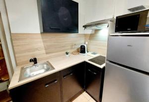 a small kitchen with a sink and a refrigerator at T2 de charme, centre ville historique de Tarbes in Tarbes