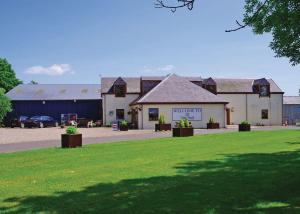 a building with a green lawn in front of it at Nethercraig Holiday Park in Alyth