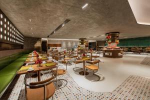 a restaurant with tables and chairs in a room at Guangzhou Hotel - Haizhu square metro station & close to Beijing road in Guangzhou