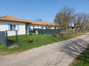 a house with a fence on the side of a road at Au coeur de la nature in Saint-Vincent-Jalmoutiers