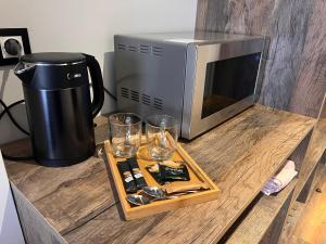 a counter with a microwave and glasses on it at Winter Flat - Orange Ski in Gudauri