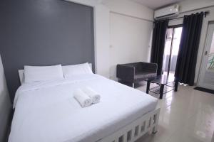 a bedroom with a large white bed with towels on it at Sakun Place in Bangna