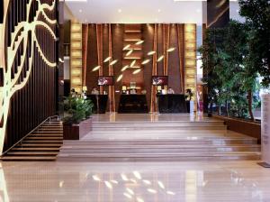 eine Lobby eines Hotels mit Treppen und Leuchten in der Unterkunft FUGO Banjarmasin in Banjarmasin