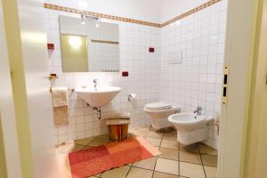 a bathroom with a sink and a toilet and a mirror at Appartamenti LEON D'ORO in Riva del Garda +46 photos