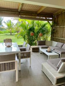 a patio with couches and a table and chairs at Villa Barachois in Calodyne