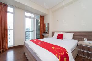 een slaapkamer met een bed en een groot raam bij RedLiving Apartemen Puri Orchard - Prop2GO Home Tower Magnolia in Jakarta