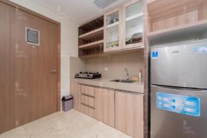 een kleine keuken met een koelkast en een wastafel bij RedLiving Apartemen Puri Orchard - Prop2GO Home Tower Magnolia in Jakarta