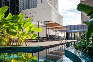 乔治市Citadines Connect Georgetown Penang的大楼内一个带桌椅的游泳池