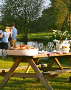 a picnic table with a plate of food on it at La Coulombe Manoir De Hérouville in Litteau