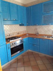 una cucina blu con piano cottura e lavandino di 252 Via Udine a Gallipoli