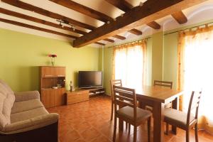 comedor con mesa y TV en Apartamentos La Pastora, en Peñarroya de Tastavins