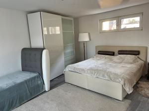 ein Schlafzimmer mit einem weißen Bett und einem Stuhl in der Unterkunft Apartment Meditari Bonn-Muffendorf in Bonn