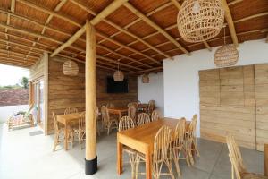 a dining room with wooden tables and chairs at Ohana Surf Guest House in Ahangama