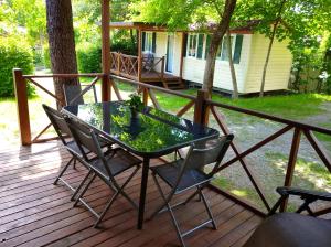 eine Terrasse mit einem Tisch und Stühlen auf einer Terrasse in der Unterkunft Villaggio Turistico Il Lago Dorato in Carlazzo