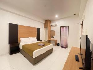 a bedroom with a bed and a flat screen tv at DZ Hotel Salor in Kota Bharu