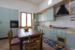 una cocina con una mesa de madera y un bol de fruta. en Villetta Il Gallo, en Mazara del Vallo