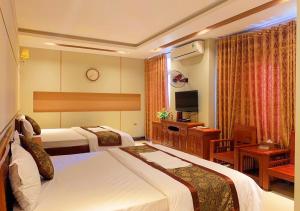 um quarto de hotel com duas camas e uma televisão em Khách Sạn Hoàng Gia 2 Lào Cai em Lao Cai