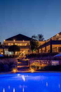 un edificio con una piscina di fronte ad essa di notte di Mantis Akagera Game Lodge a Akagera