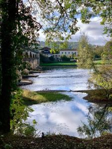 Brasseurs Du Pont - Microbrasserie avec chambres في Siorac-en-Périgord: نهر وانعكاس السماء في الماء