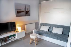 mały salon z kanapą i telewizorem w obiekcie Quo Vadis - Proche plage et parking privé w Arcachon