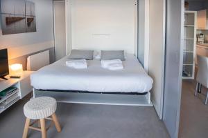 niewielka sypialnia z łóżkiem i stołkiem w obiekcie Quo Vadis - Proche plage et parking privé w Arcachon
