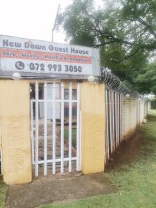 a new fence guest house with a sign on it at New Dawn Guest House in Brakpan